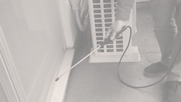 建物外周でゴキブリ対策の薬剤処理を行う様子
