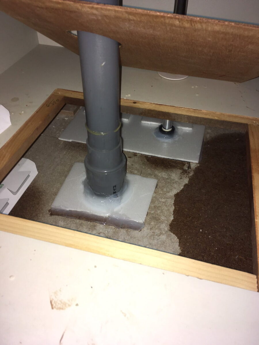 排水管と細い配管の根元を板材で処理