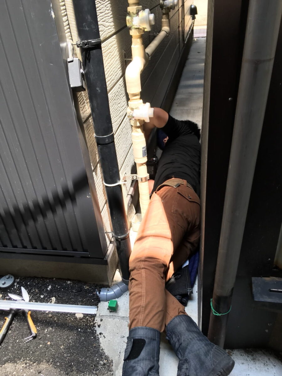 狭い建物外周で低い位置を確認する作業