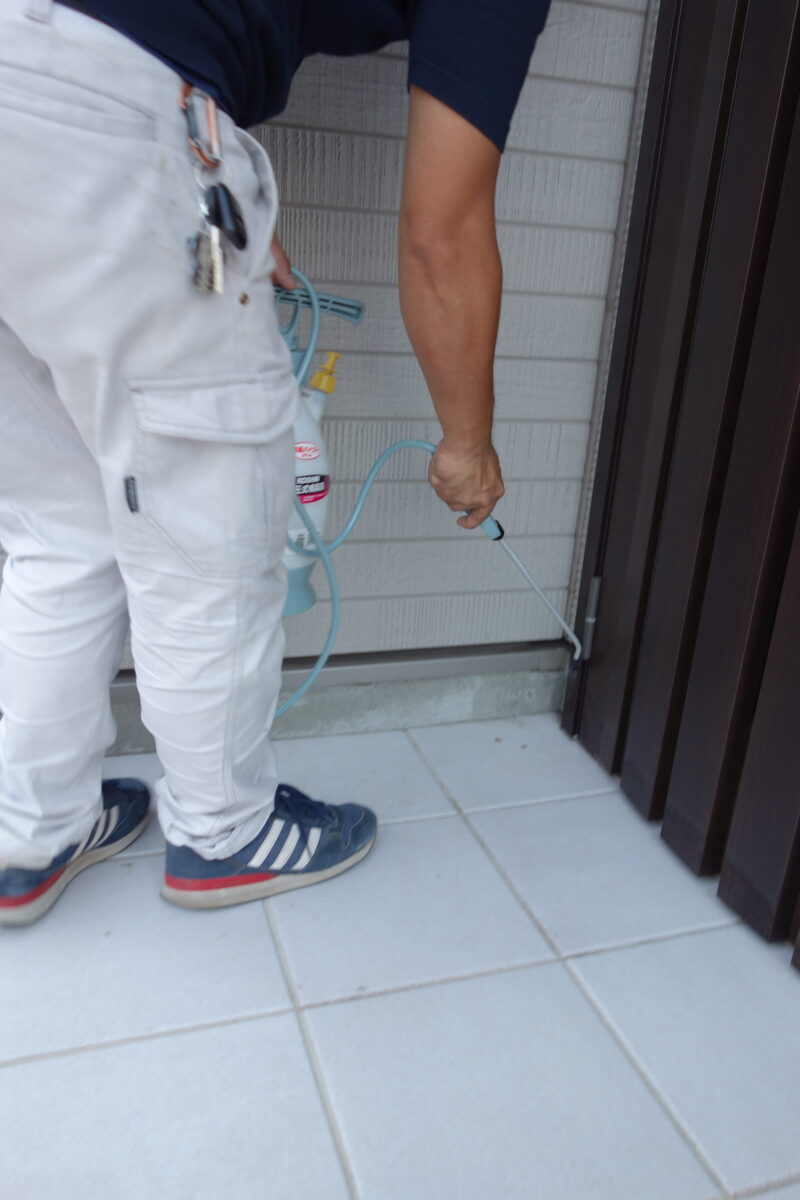 玄関枠の下側へノズルを向けたゴキブリ対策