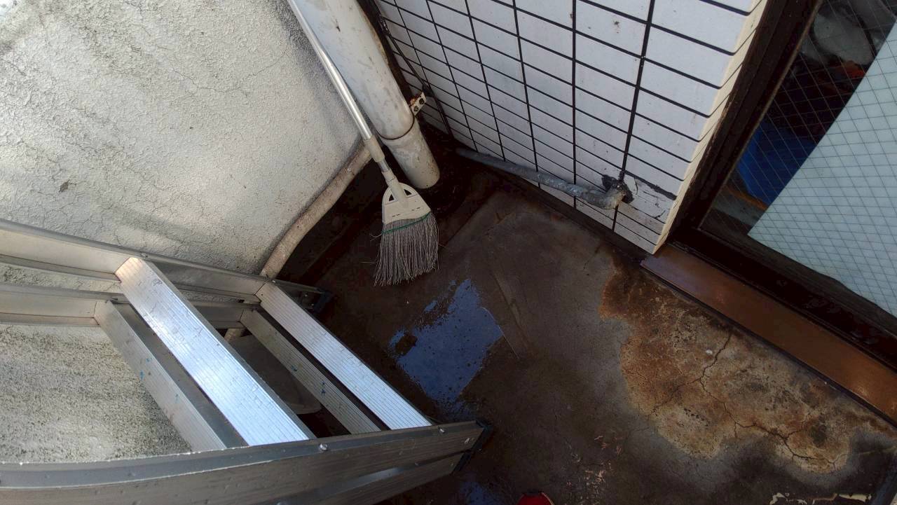 所沢市の鳩駆除：窓際とベランダの角を清掃する作業